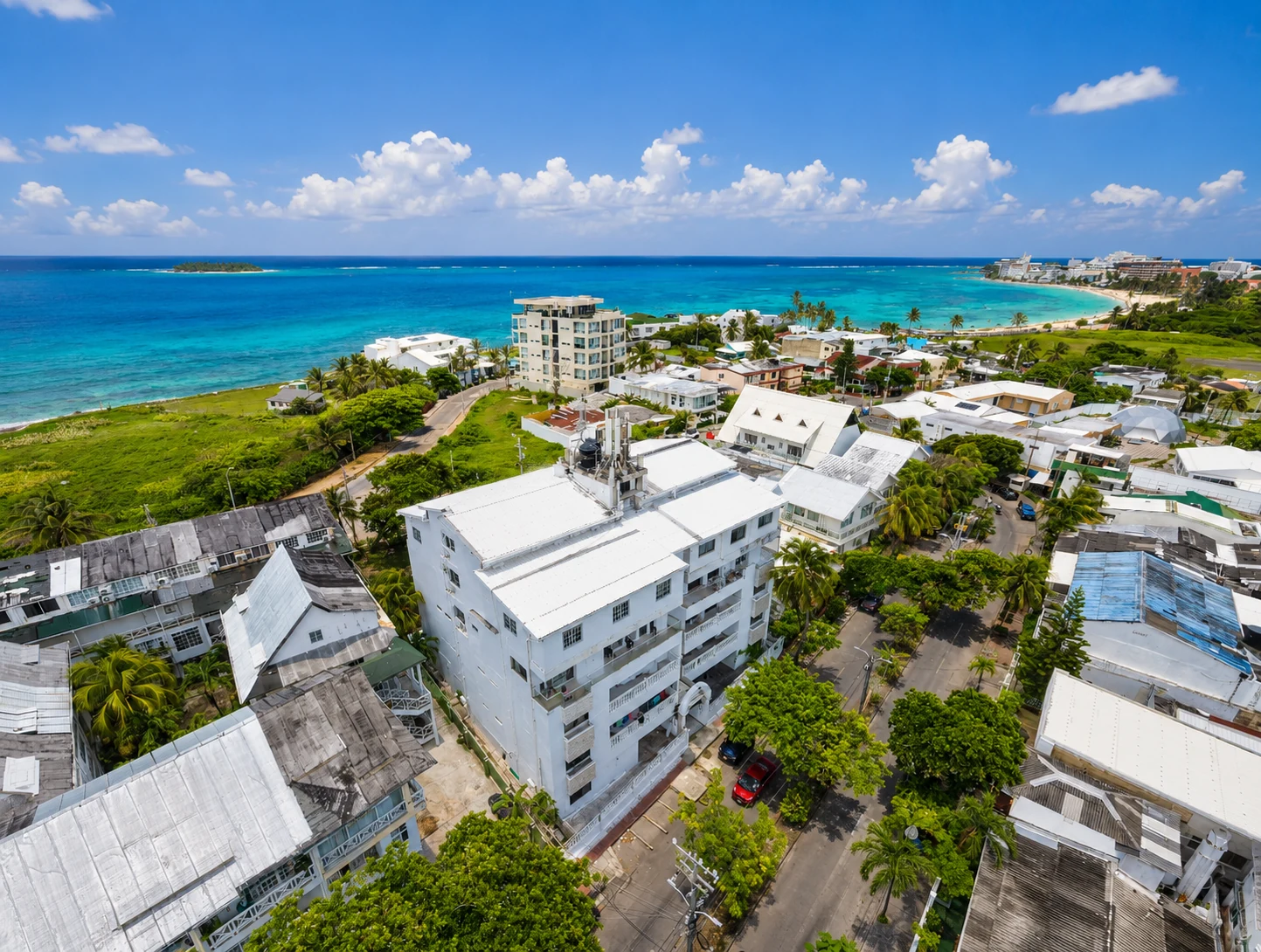 Vista aérea de Sarie Bay: el edificio blanco, el arrecife y Johnny Cay al fondo.